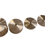 Five small metal discs with a central hole arranged diagonally on a green background.