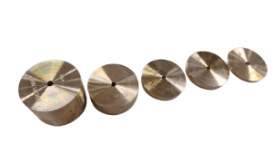 Five small metal discs with a central hole arranged diagonally on a green background.