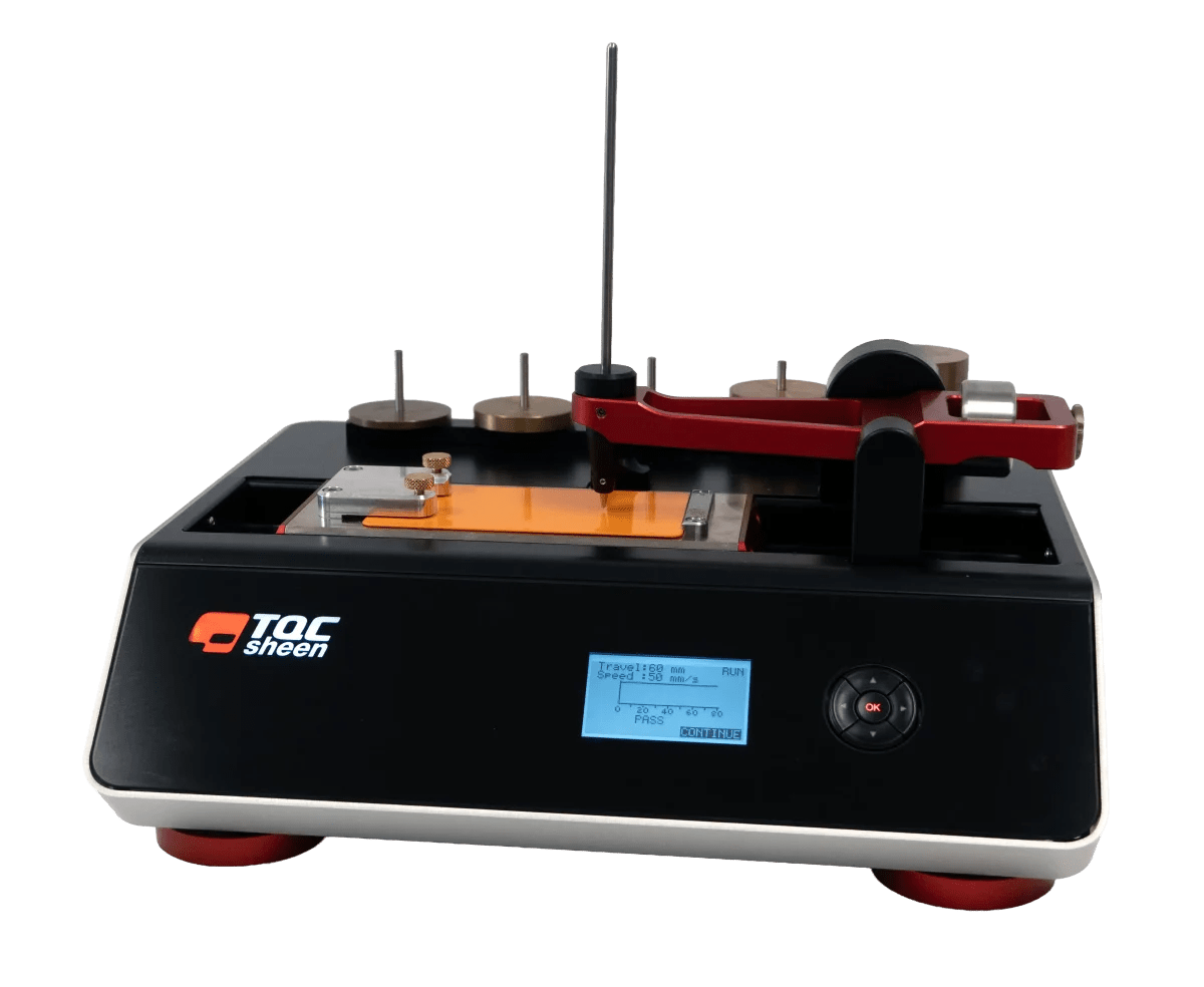 TQC Sheen coating tester on a black base with a blue display and red clamping arm